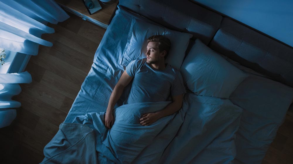 Homme qui dort dans son lit