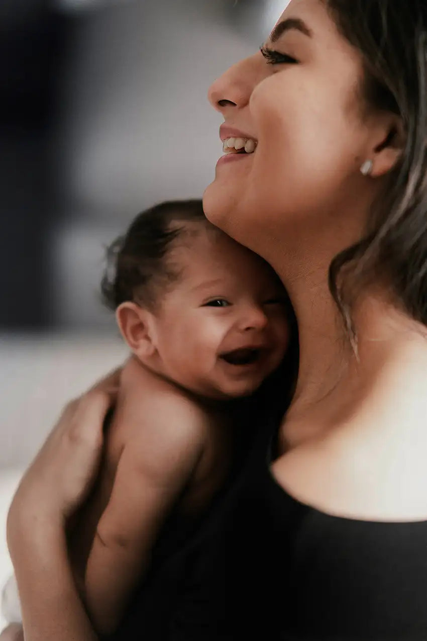 une mère tient son bébé heureux dans ses bras