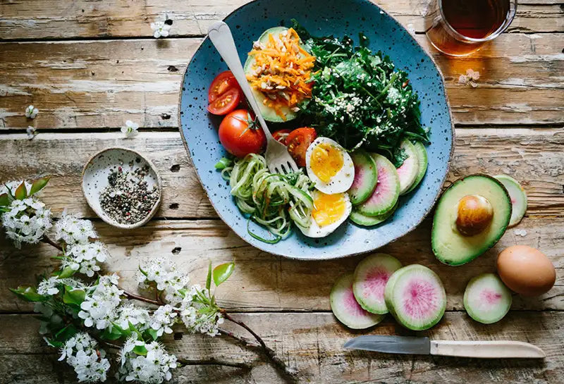 un plat sain avec des avocats oeufs kale et légumes