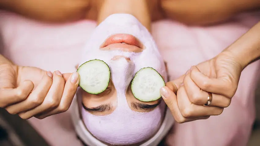 femme qui fait une séance de détox avec des tranches de concombre sur les yeux